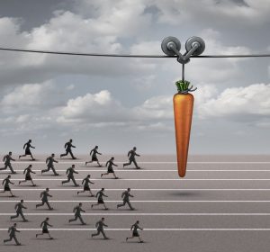 43851108 - employee incentive business concept as a group of businessmen and businesswomen running on a track towards a dangling carrot on a moving cable as a financial reward metaphor to motivate for a goal.